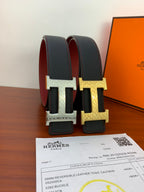 Reversible leather belt showing black and maroon straps with H buckle, card below