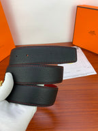 Black leather belt with red edge stitching, folded strap with paper nearby
