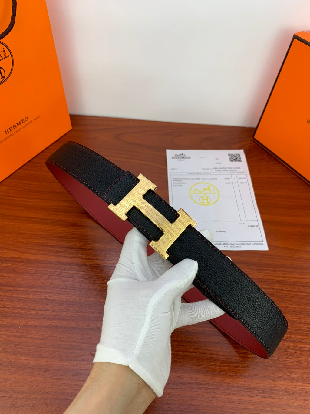 Hermes belt in black textured leather with gold H buckle, shown folded