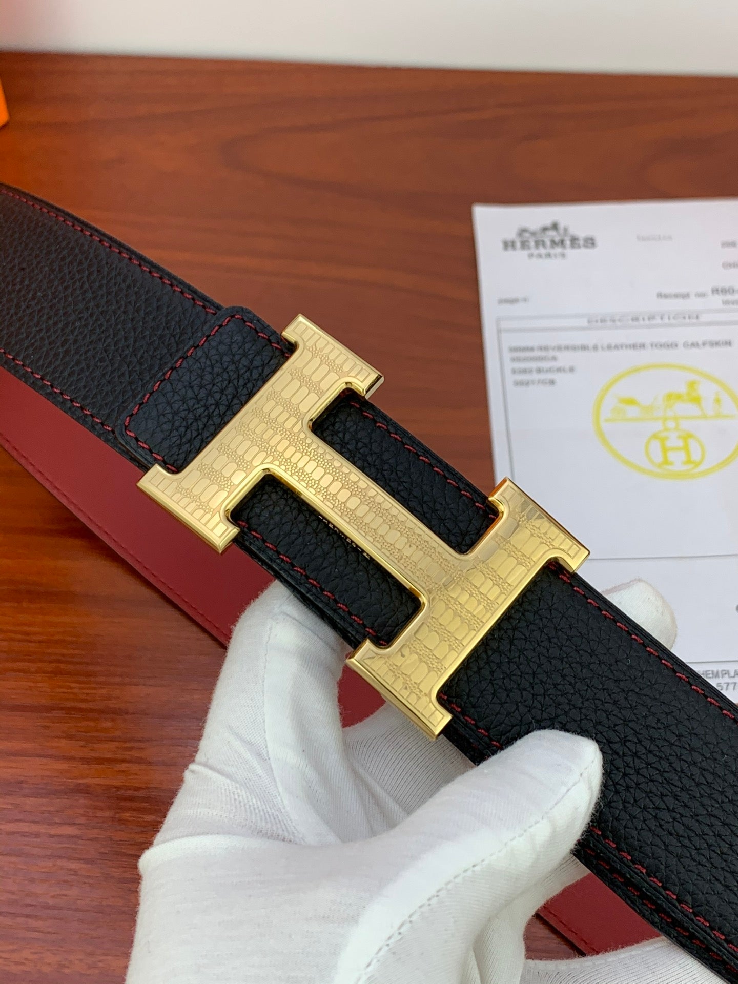 Hermes belt close-up: black leather with gold H buckle and keeper
