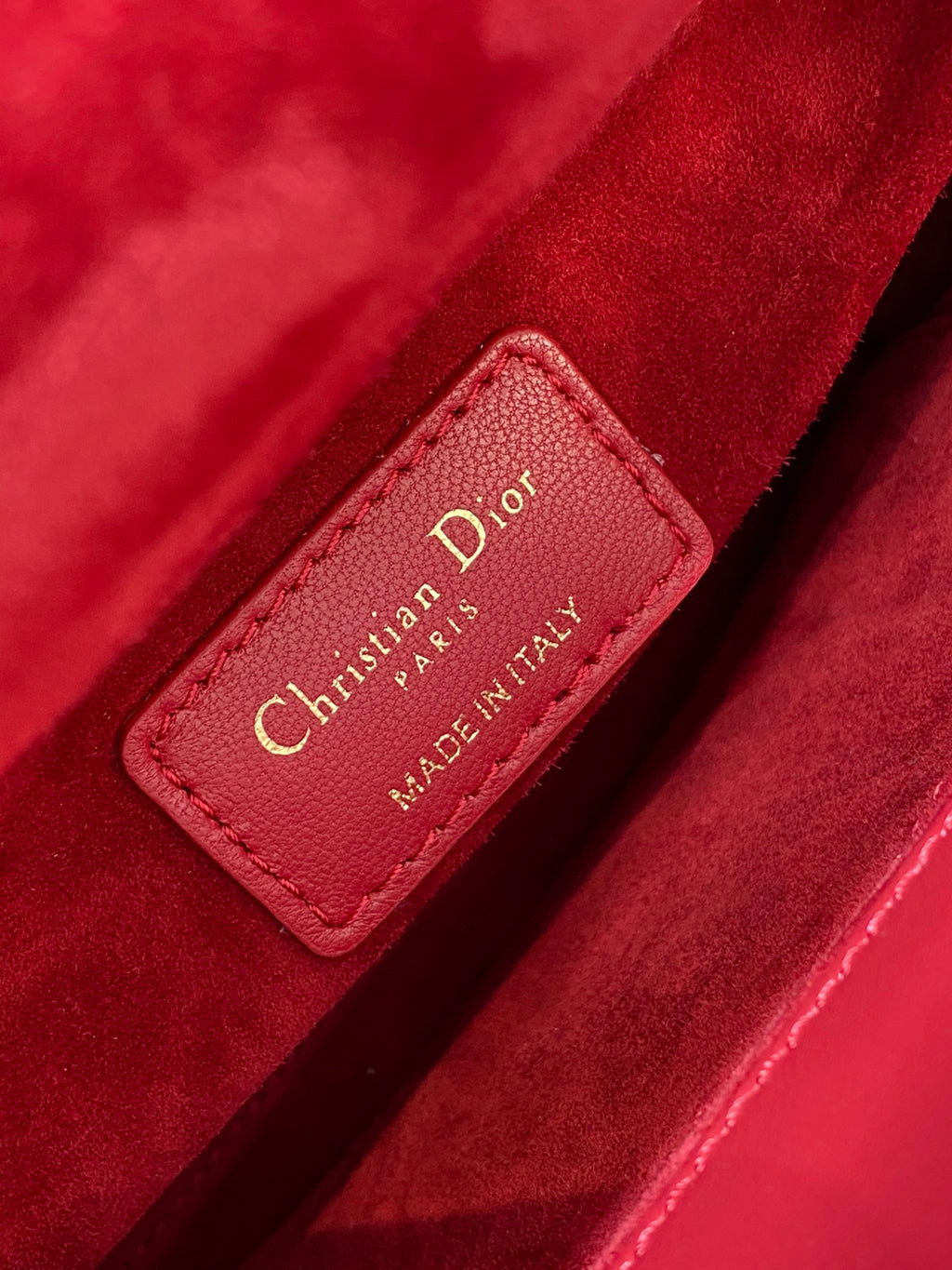 Red leather Dior label reading Christian Dior PARIS MADE IN ITALY