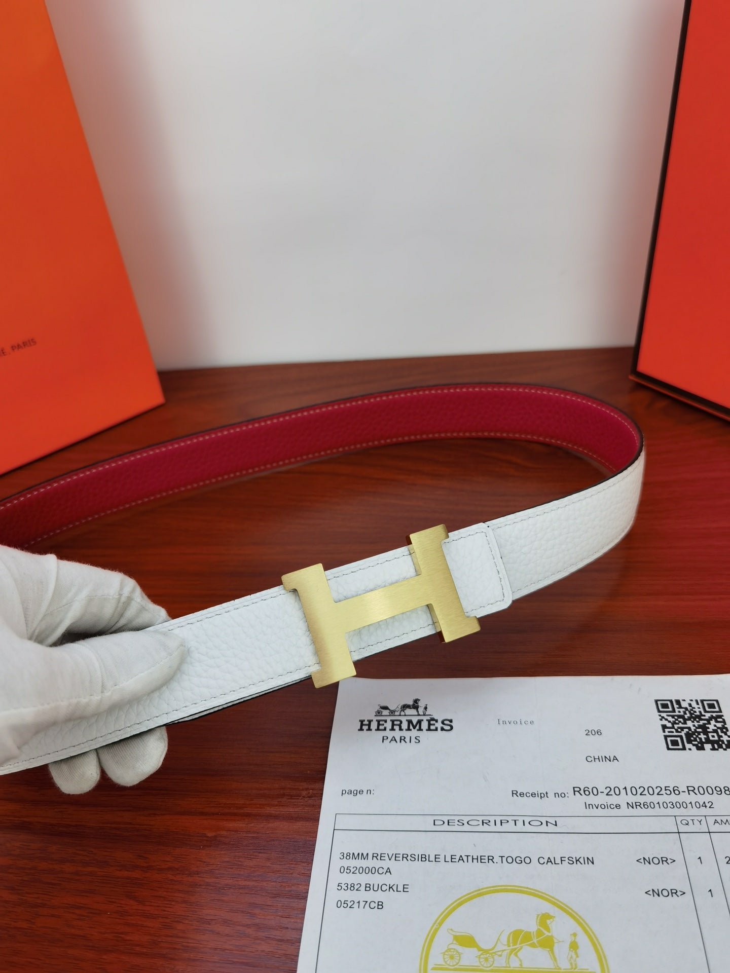 Hermes belt with light blue strap and gold-toned buckle, red underside visible