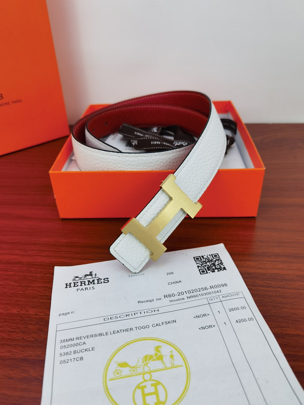 Hermes reversible belt with light blue strap, gold-toned buckle, and dark lining peeking