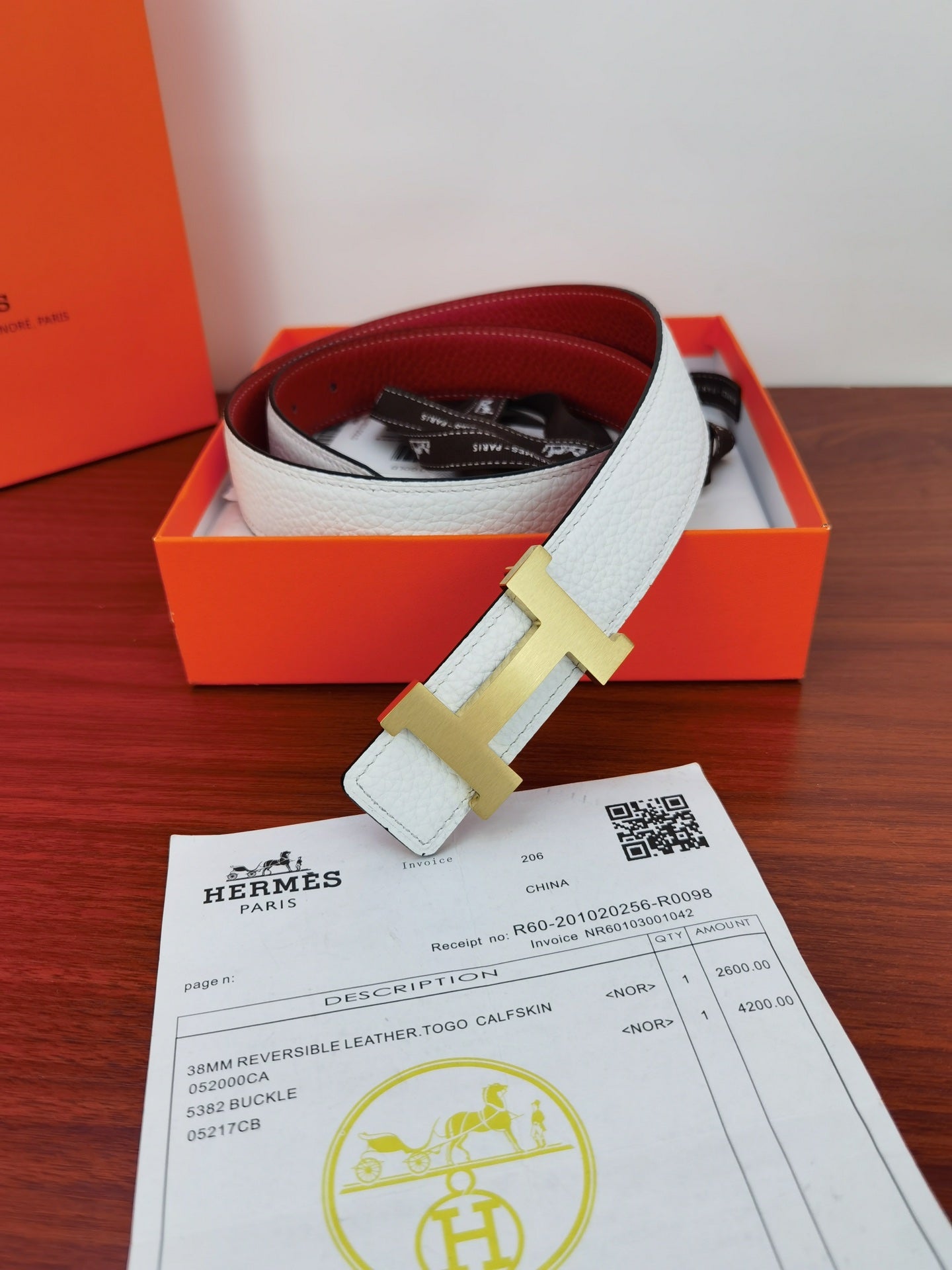 Hermes reversible belt with light blue strap, gold-toned buckle, and dark lining peeking