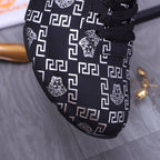 Versace luxury shoes close-up of dark upper with white geometric pattern and lion graphic