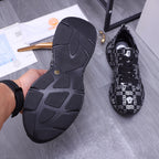 Versace luxury shoes outsole view with dark ribbed rubber tread and white pattern upper