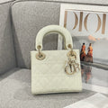 Cream quilted Dior handbag with glossy top handles and gold hardware
