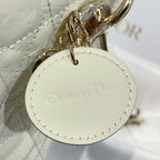 Round charm stamped "Christian Dior" on cream quilted Dior handbag