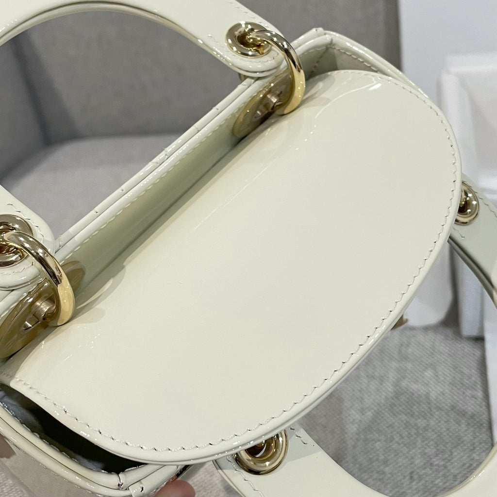 Cream Dior handbag with oval gold handle hardware and quilted front