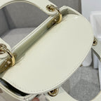 Cream Dior handbag with oval gold handle hardware and quilted front