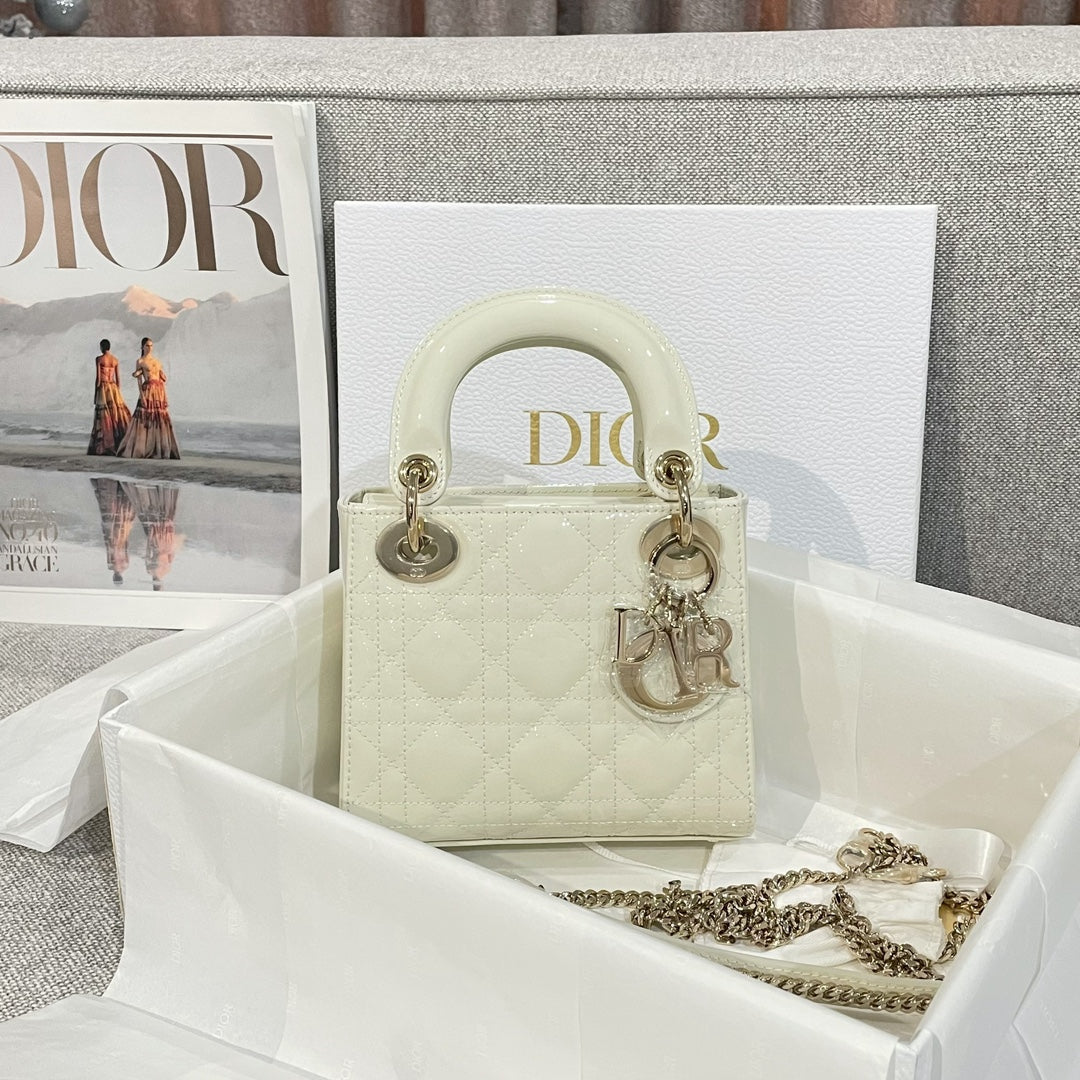 Cream quilted Dior handbag with top handles, gold hardware, and chain strap