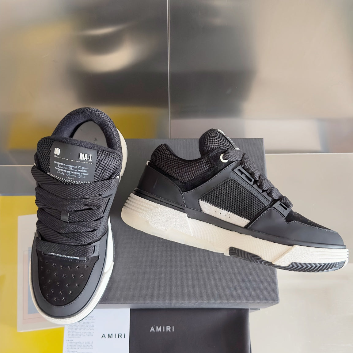 Amiri sneakers with dark knit upper, black lace-up front, and white midsole
