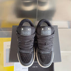Amiri sneakers front view, dark knit upper, black laces, and white rubber sole