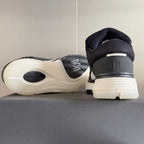 Amiri sneaker heel view with dark upper, ribbed sole tread, and logo on heel tab