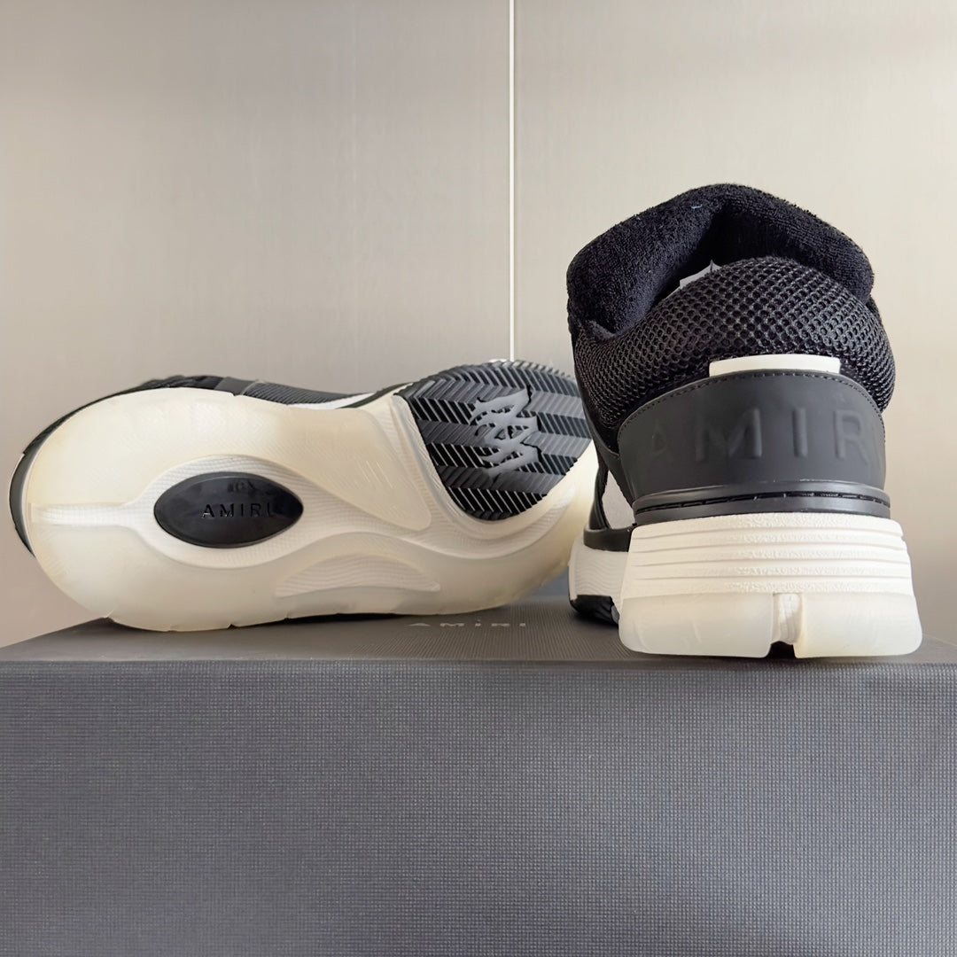 Amiri sneaker heel view with dark upper, ribbed sole tread, and logo on heel tab