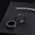 Two dark-tone rings with circular crystal borders and raised engraved detailing
