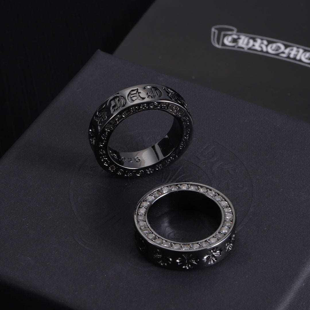 Two rings: one dark-tone with engraved band, one silver-tone with crystal outer edge