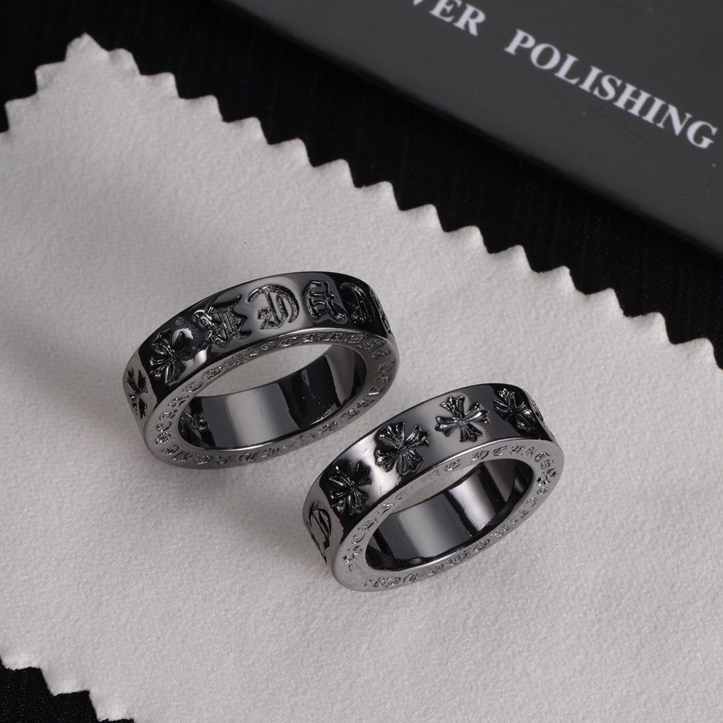 Pair of silver-tone rings with engraved motifs and sparkling stone outer borders