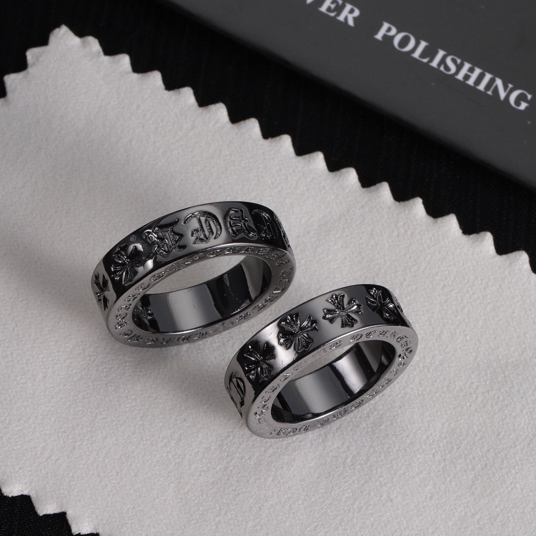 Pair of silver-tone rings with engraved motifs and sparkling stone outer borders