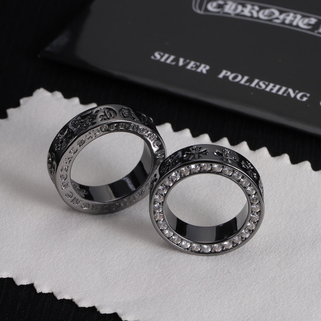 Pair of silver-tone rings with jeweled borders and engraved dark patterned edges