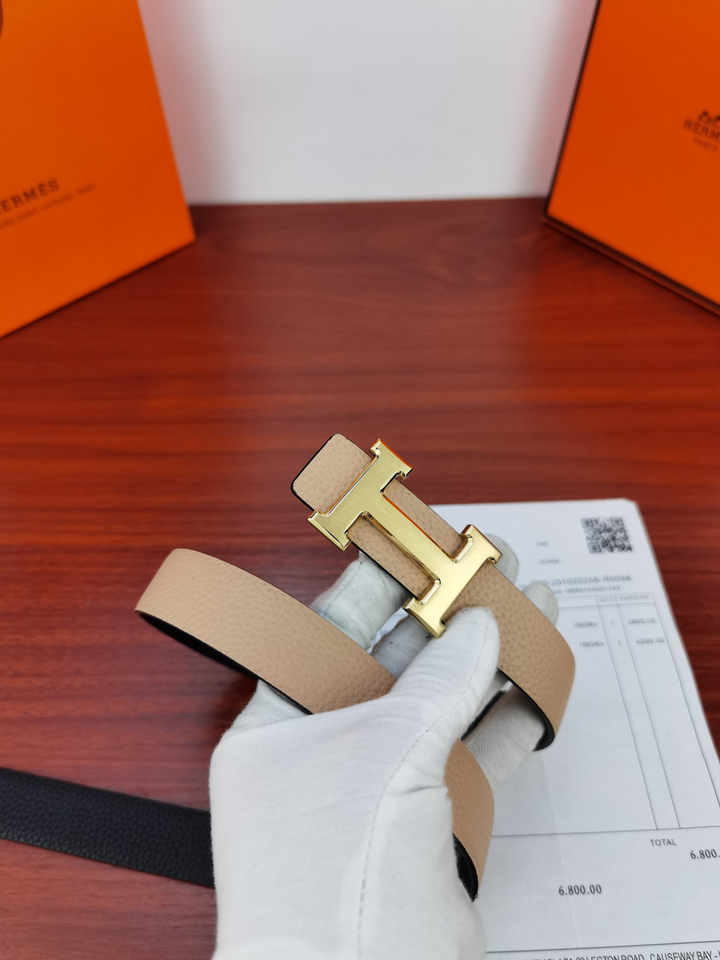 Hermes belt close-up: light beige leather strap with gold-tone H buckle detail