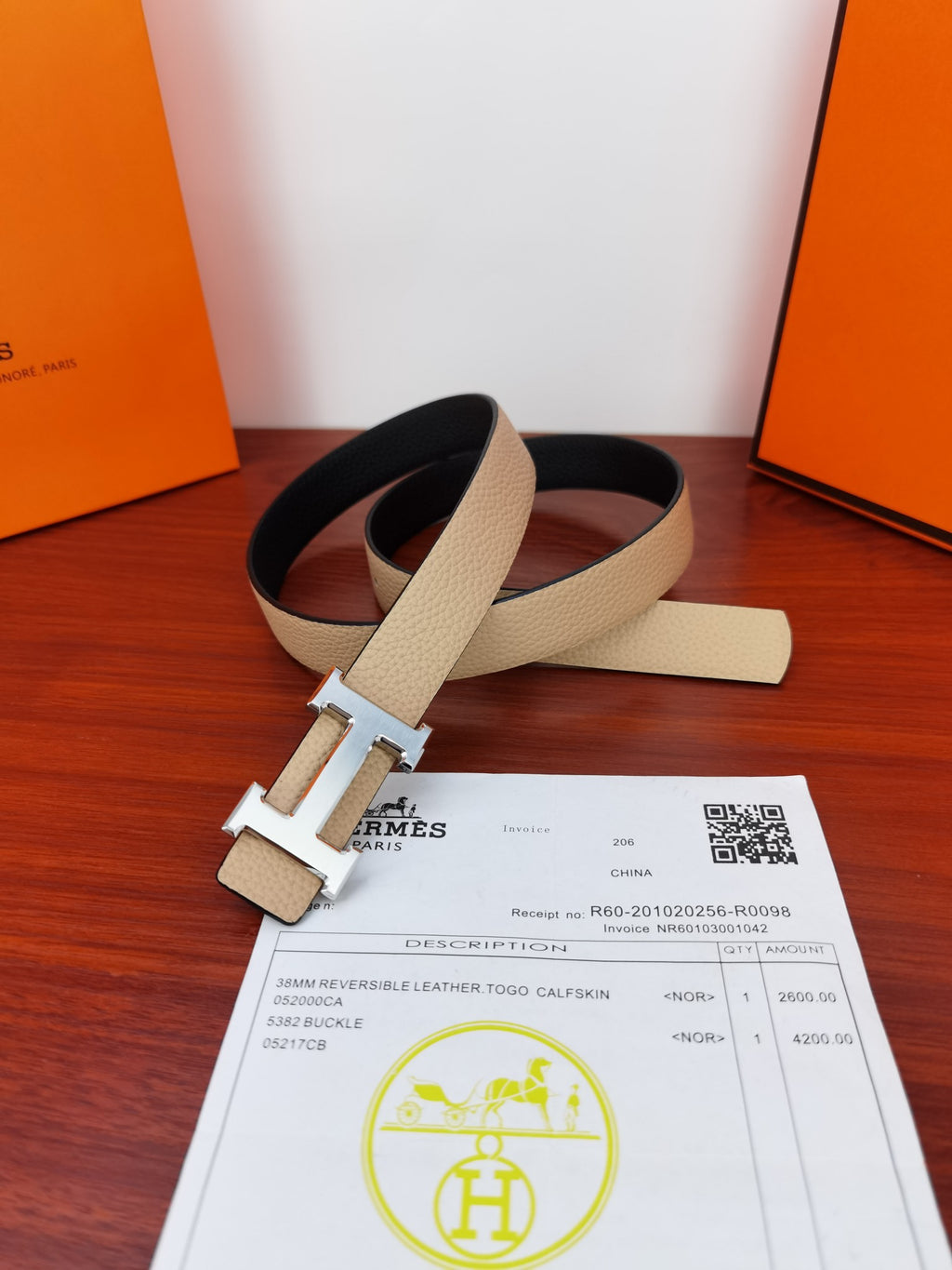 Hermes reversible leather belt with light beige strap, black underside, and metal H clasp