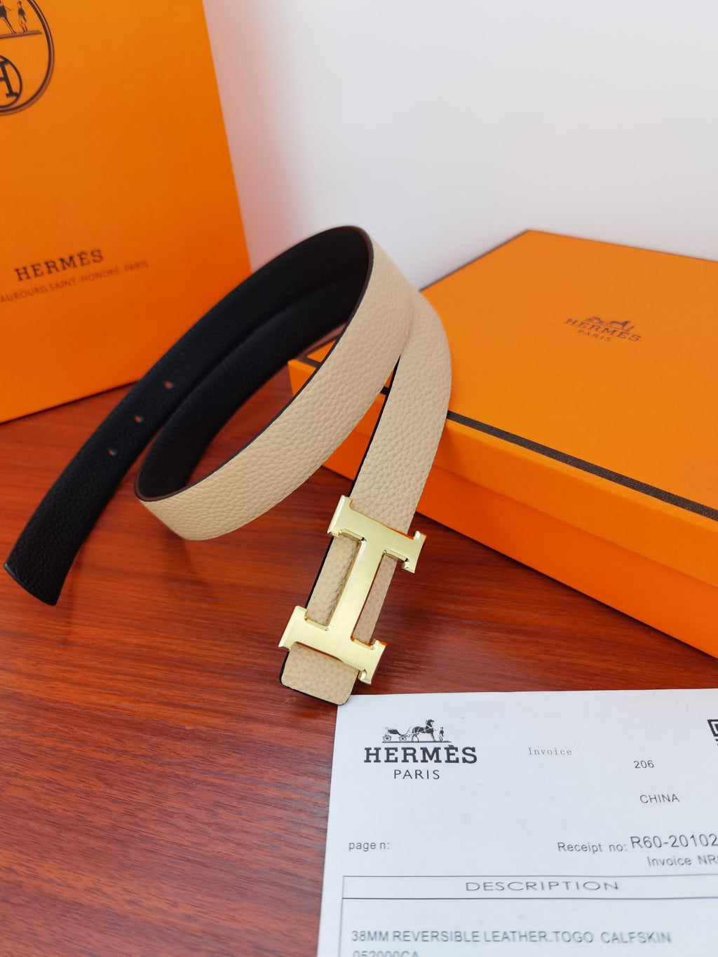 Hermes reversible belt laid out: light beige and black leather with H clasp