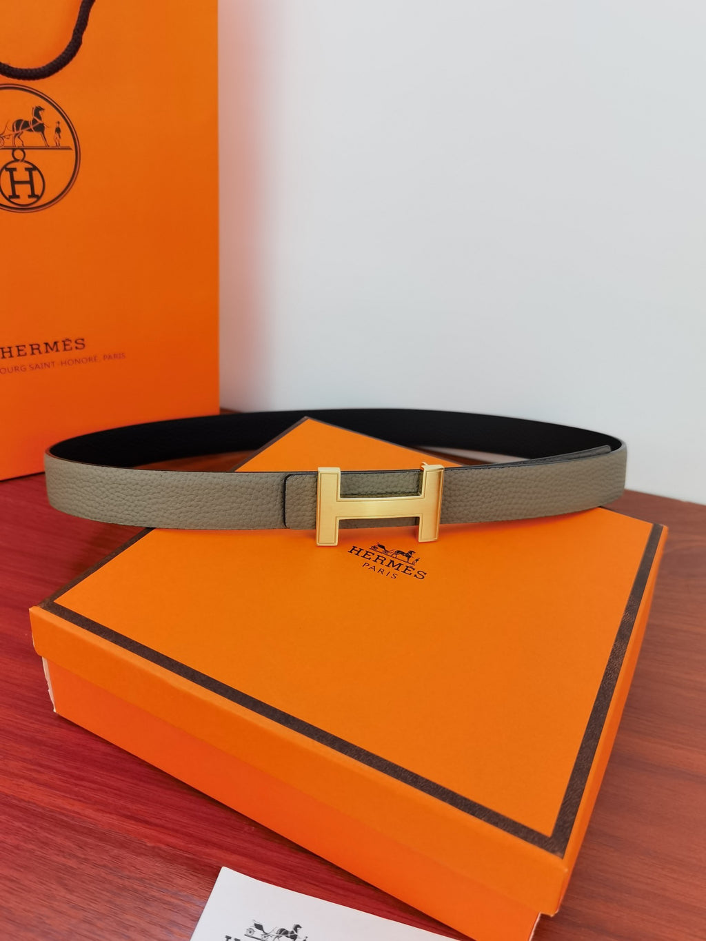 Reversible leather belt with light gray strap and gold-tone buckle