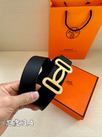 Dark leather belt with silver-toned buckle, shown in hand