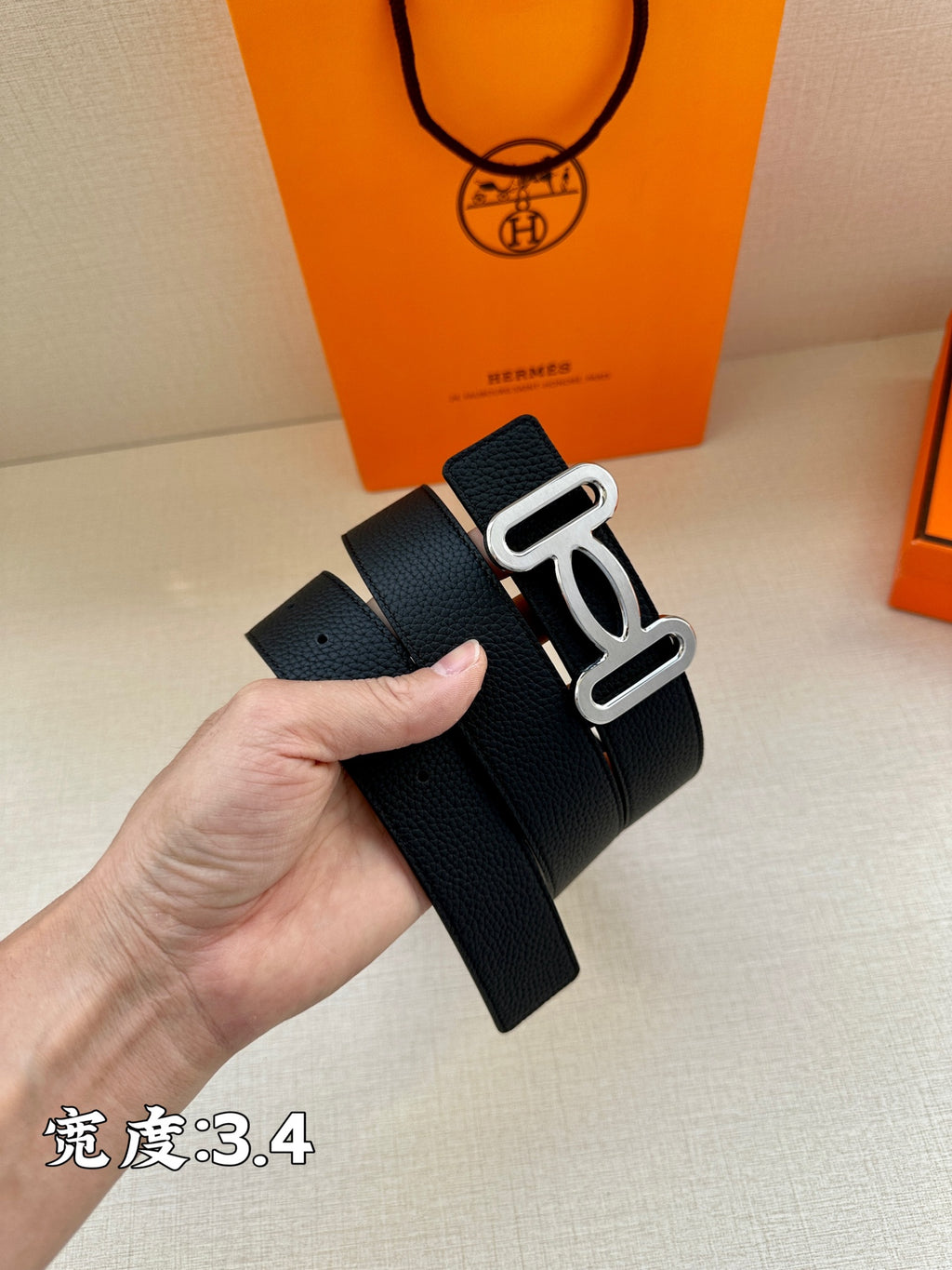 Dark leather belt with silver-toned buckle and textured surface, clasp visible