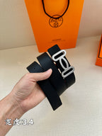 Dark leather belt with silver-toned buckle and textured surface, clasp visible