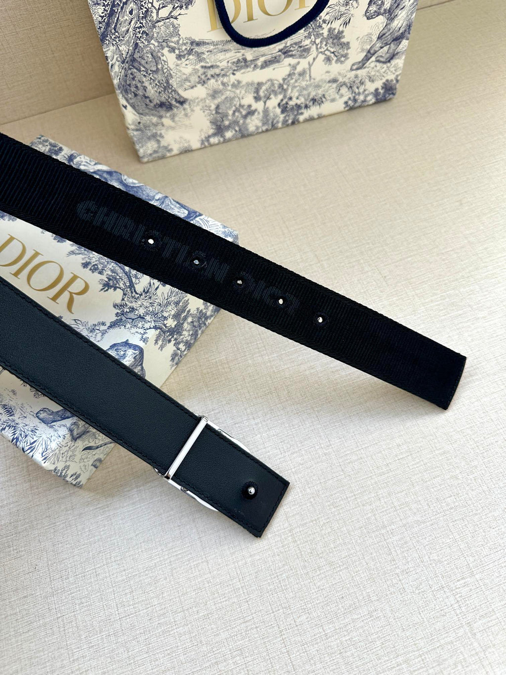 Navy belt with silver-tone buckle and perforated adjustment holes