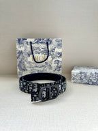 Dior logo belt with dark patterned strap and silver-toned buckle, stacked on surface