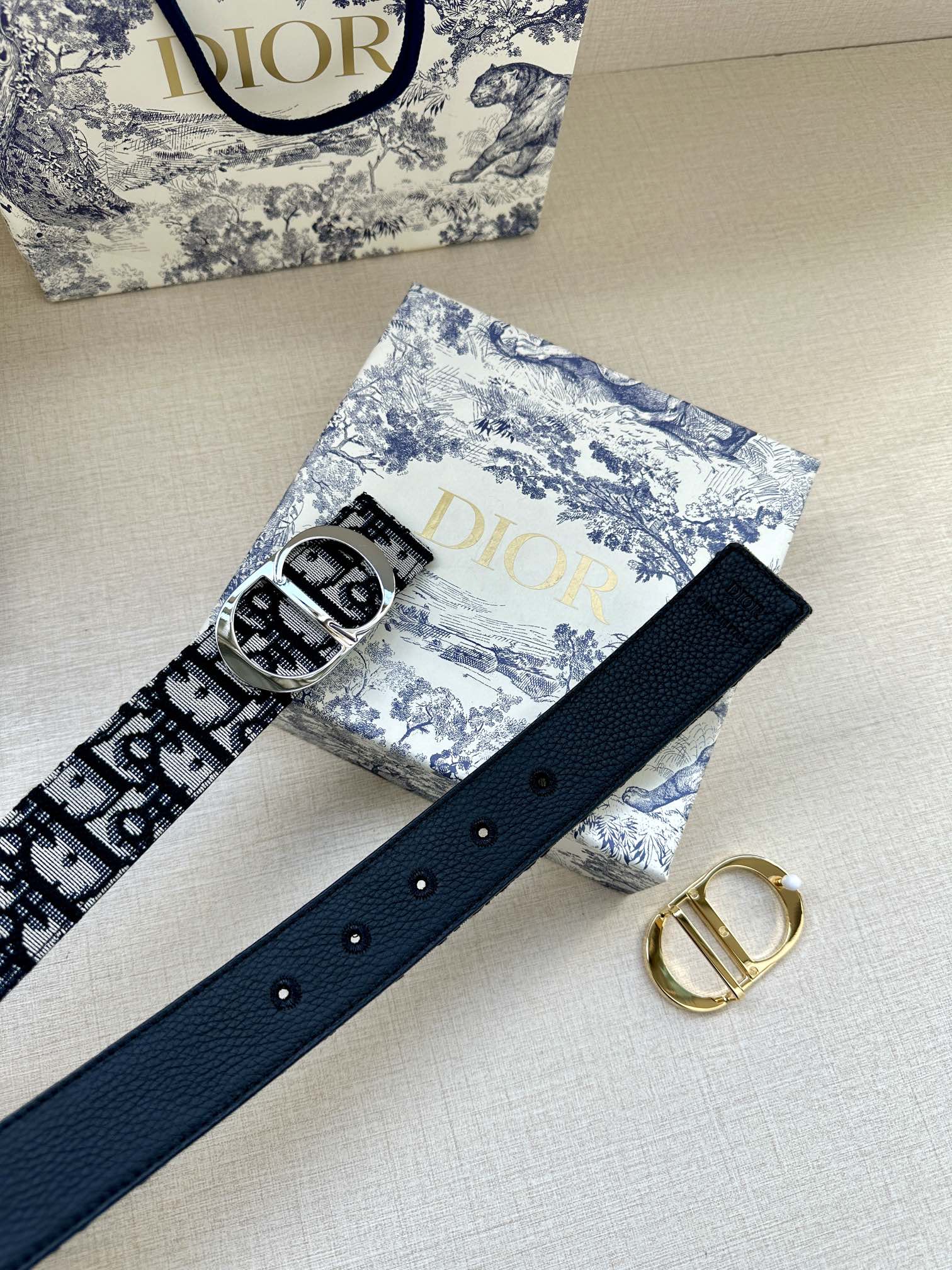 Navy leather belt with silver buckle and evenly spaced eyelets