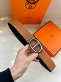 Tan leather belt with large O-shaped silver buckle and keeper strap