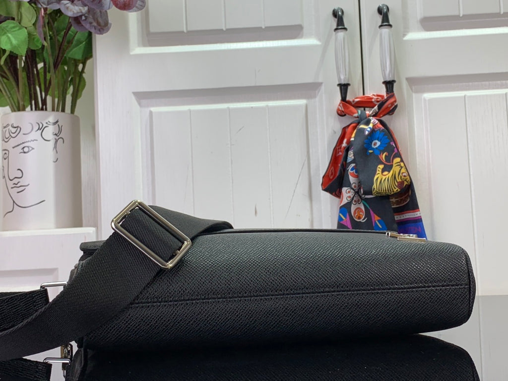 Louis Vuitton bag side view with adjustable strap and gold buckle, black textured leather