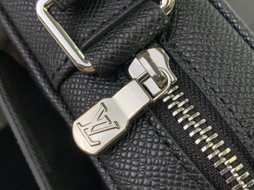 Louis Vuitton bag zipper hardware with metal pull and LV crest on textured black leather