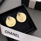 Gold CHANEL stud earrings showing backs with post hardware, in black jewelry box