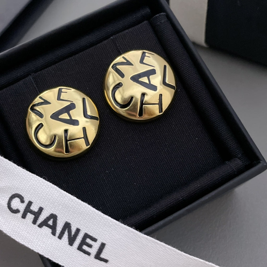 Round gold CHANEL logo stud earrings with interlocking letters, shown in black box