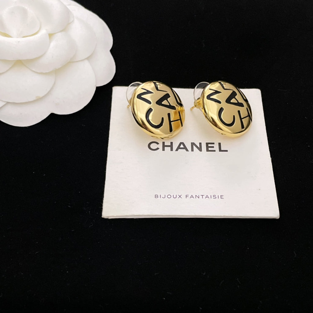 Round gold CHANEL logo stud earrings with interlocking letters on a white card
