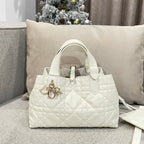 Quilted white handbag with top handles and gold logo charm