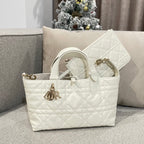 Quilted white handbag side view with top handles and front logo charm