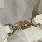 Gold-tone clasp and chain on white quilted handbag