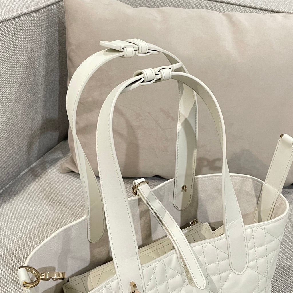 White handbag with looped handle straps and gold-tone rings