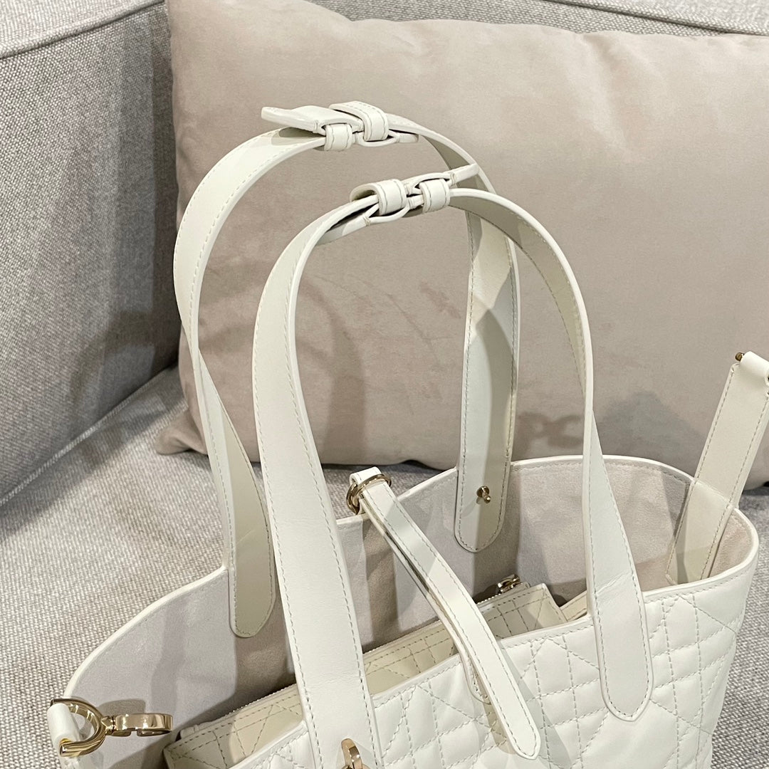 White handbag with looped handle straps and gold-tone rings