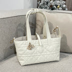 White quilted tote bag with top handles and front logo charm