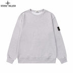Grey crewneck sweatshirt with long sleeves and Stone Island sleeve patch