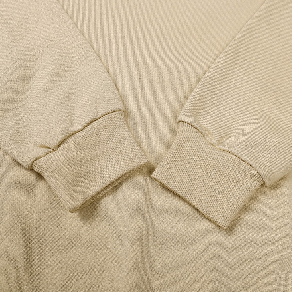 Beige crewneck sweatshirt sleeve cuffs and ribbed hem detail