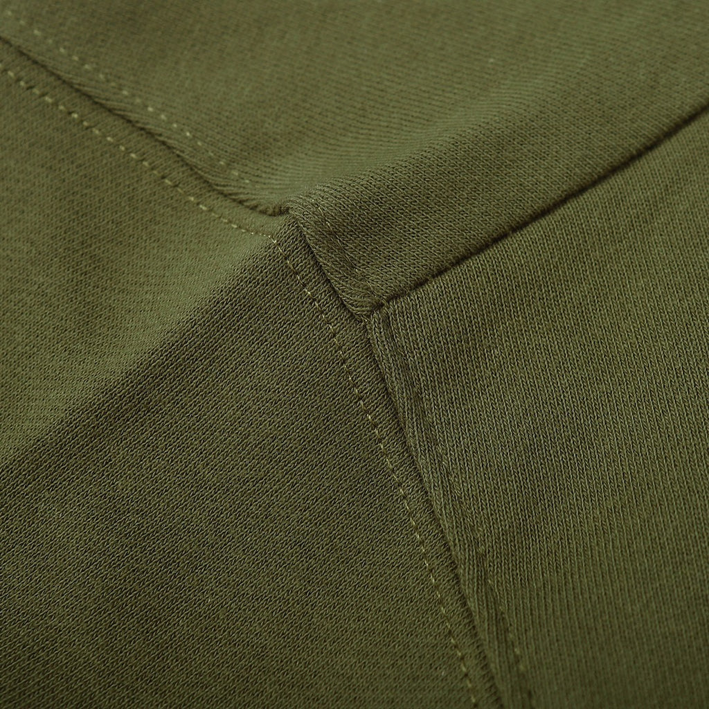 Olive green sweatshirt waistband close-up with stitched ribbed edge