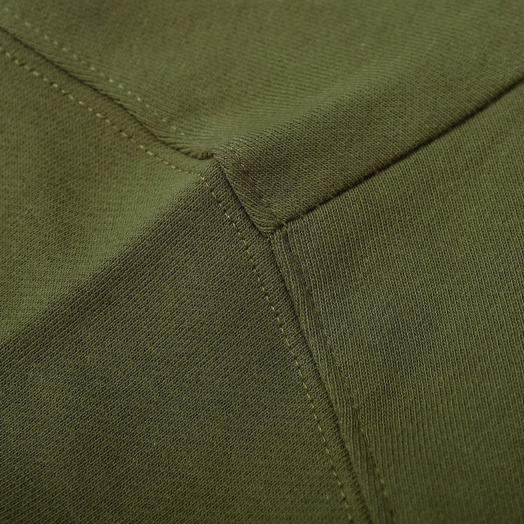 Olive green sweatshirt waistband close-up with stitched ribbed edge